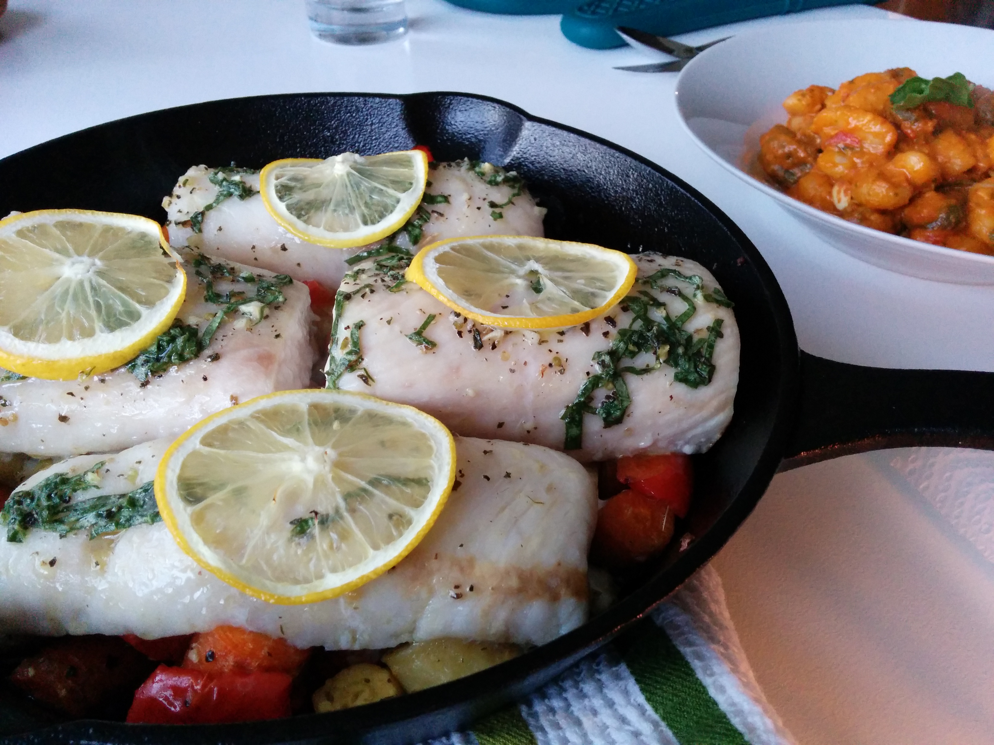 Lemon-Herb Fish That Cooks Itself in Twenty Minutes (image credits: Delicious fish in a cast iron pan with slices of lemon and herbs, CC BY 2.0, https://commons.wikimedia.org/w/index.php?curid=80212631)