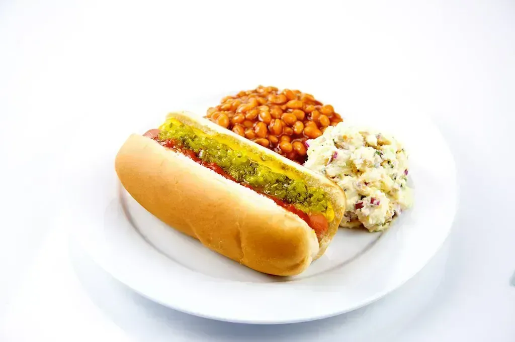 Hot Dogs and Baked Beans: The Camping Classic That Never Left Home (Image Credits: Hot Dog with Baked Beans and Potato Salad
Uploaded by the wub, CC BY 2.0, https://commons.wikimedia.org/w/index.php?curid=27753459)