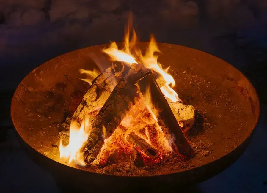 A cozy corner with a fire bowl and floor cushions (Image Credits: Pexels)
