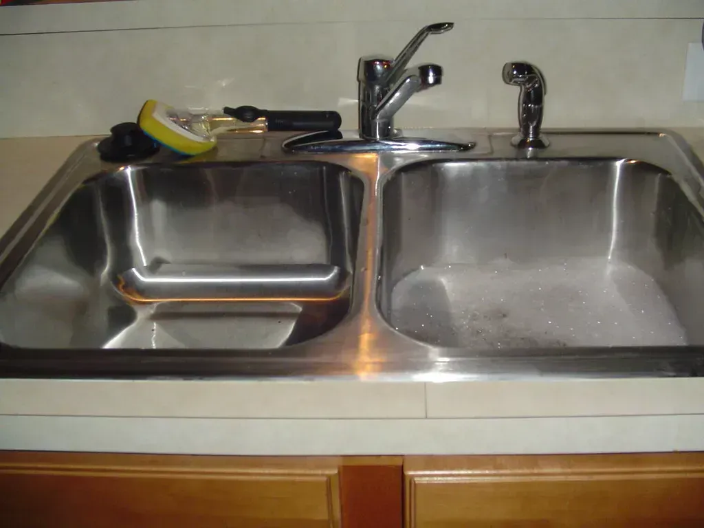 6. Running Hot Water While Pouring Grease (Image Credits: Flickr)