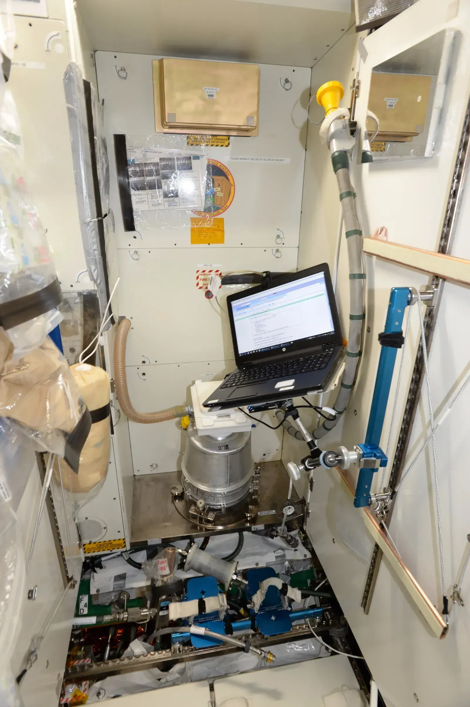 Using the Toilet in Microgravity (By Randolph Bresnik, Public domain)
