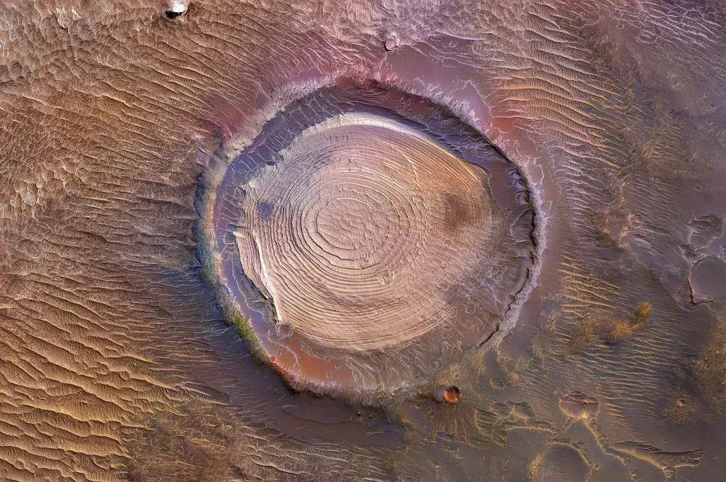 What a buried impact crater does to the local landscape (By image:NASA/JPL-Caltech/UArizona - Mariagat1959 modified image by add color, Public domain)
