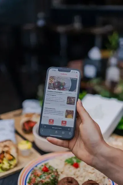 8. Comparing the menu to a photo on their phone (Image Credits: Pexels)
