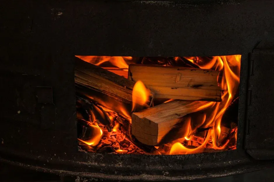 8. Stoking and tending a wood-burning stove (Image Credits: Pexels)