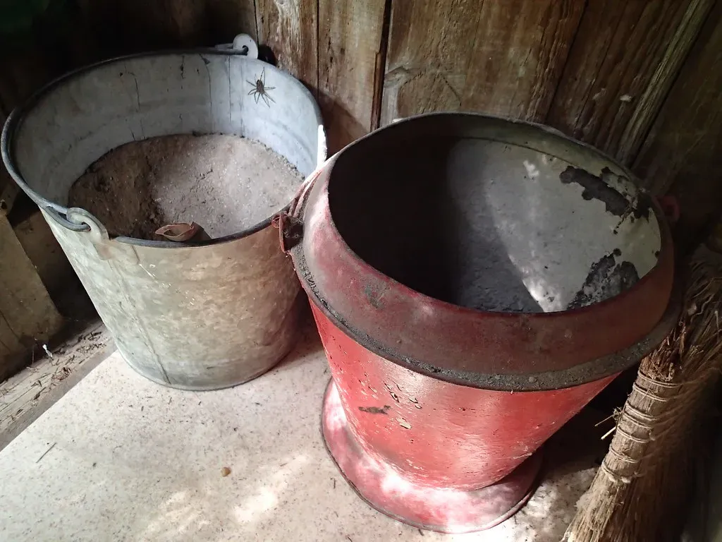 2. Emptying the ash bucket from the coal stove or furnace (Robbie1, Flickr, <a href="https://creativecommons.org/licenses/by/2.0/" target="_blank" rel="noopener">CC BY 2.0</a>)