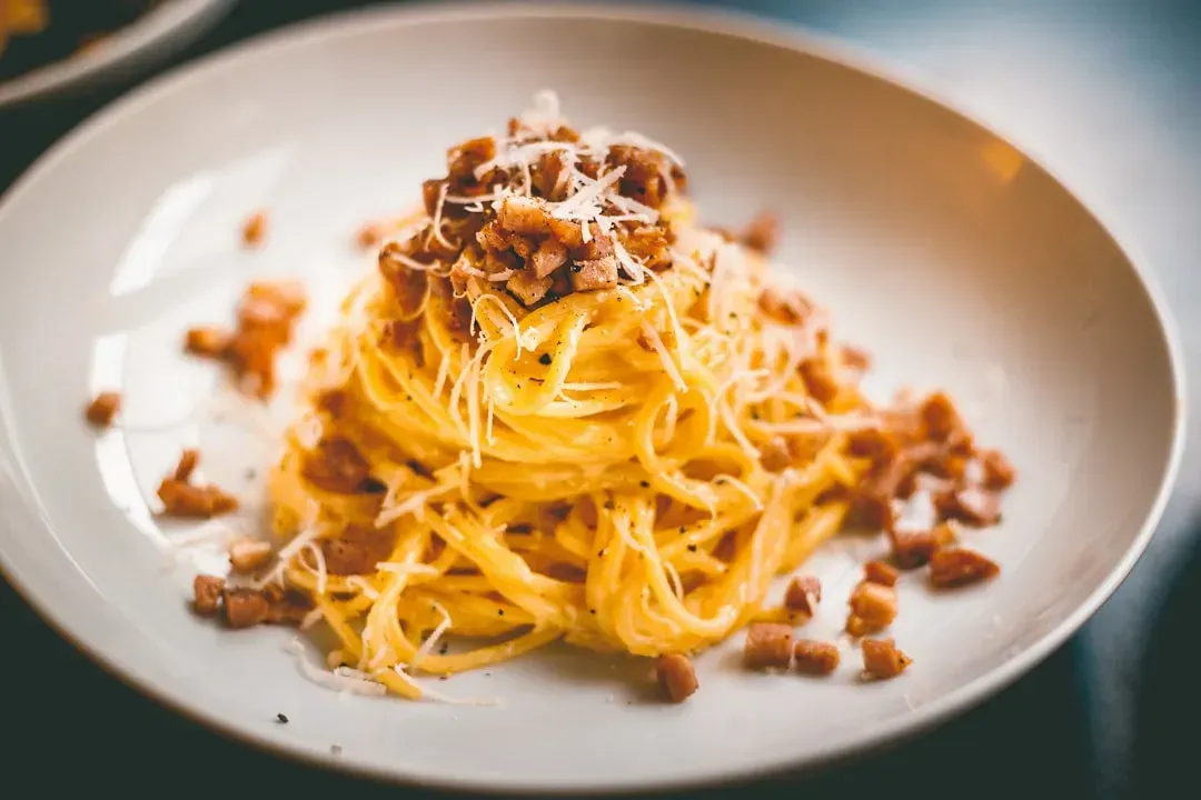 A bacon and egg pasta that borrows from carbonara logic (Image Credits: Unsplash)
