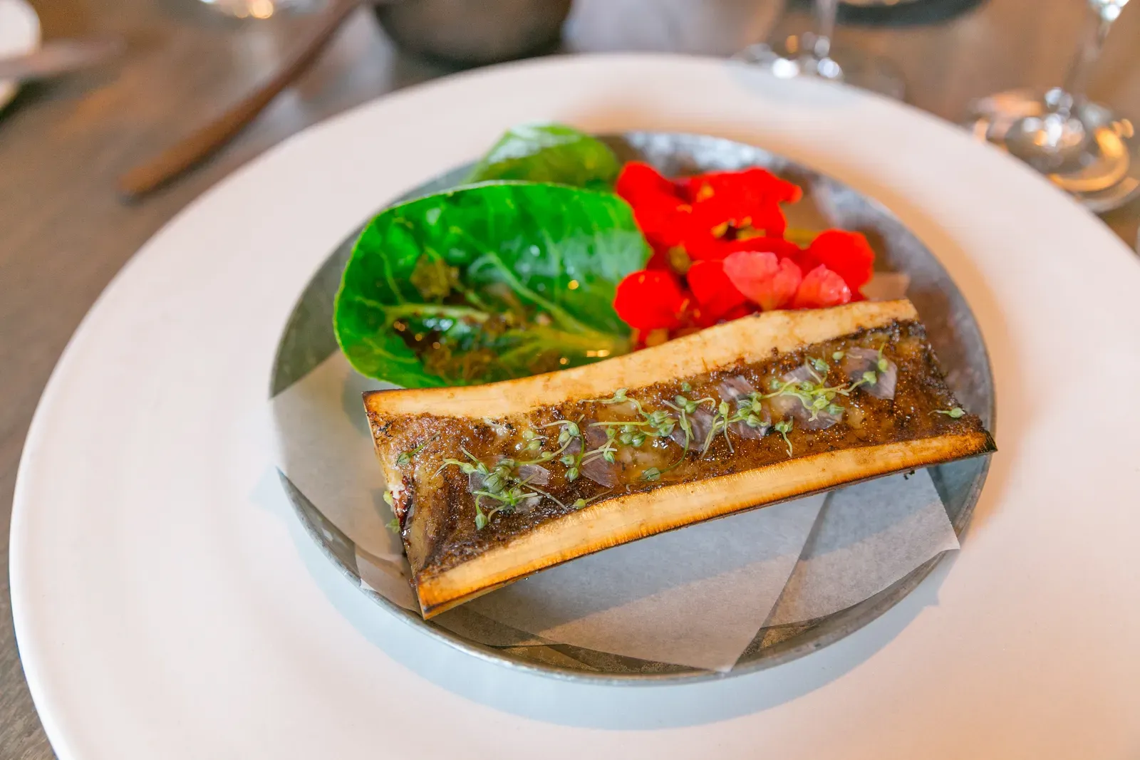 4. Bone marrow (18: Roasted Bone Marrow, Cabbage, and Nasturtium Flowers, <a href="https://commons.wikimedia.org/w/index.php?curid=67286772" target="_blank" rel="noopener">CC BY 2.0</a>)