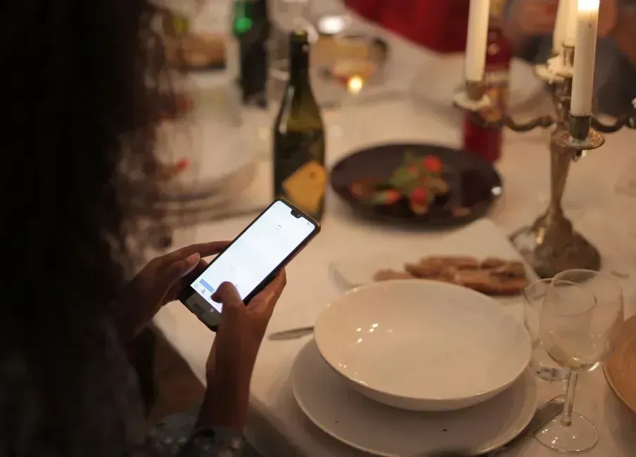 10. Scrolling through your phone during the meal (Image Credits: Pexels)