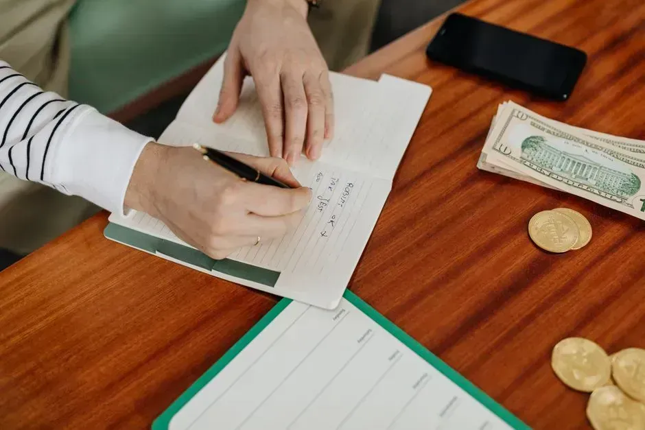 2. Balancing a checkbook by hand (Image Credits: Pexels)