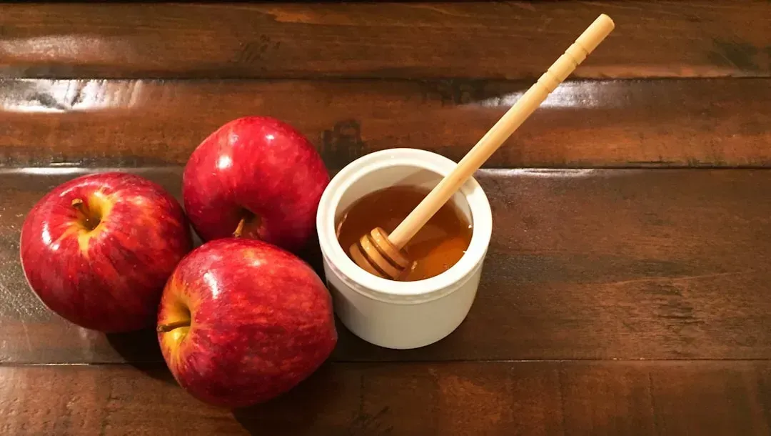 Small apple with a tablespoon of peanut butter (Image Credits: Unsplash)