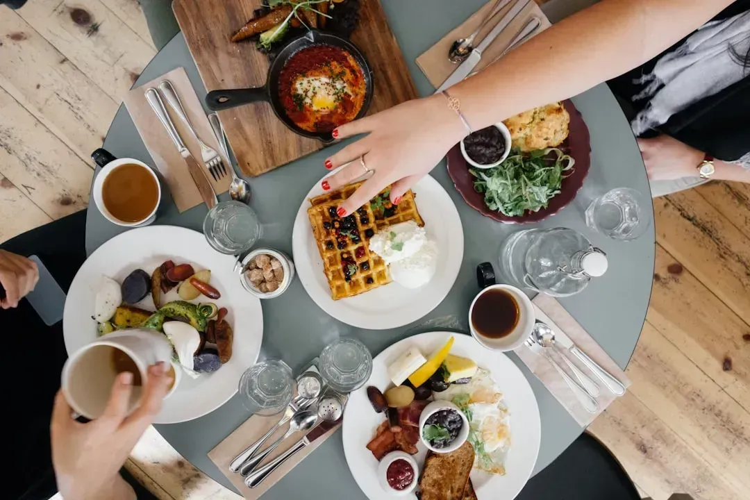 5. Reaching across the table for something (Image Credits: Unsplash)